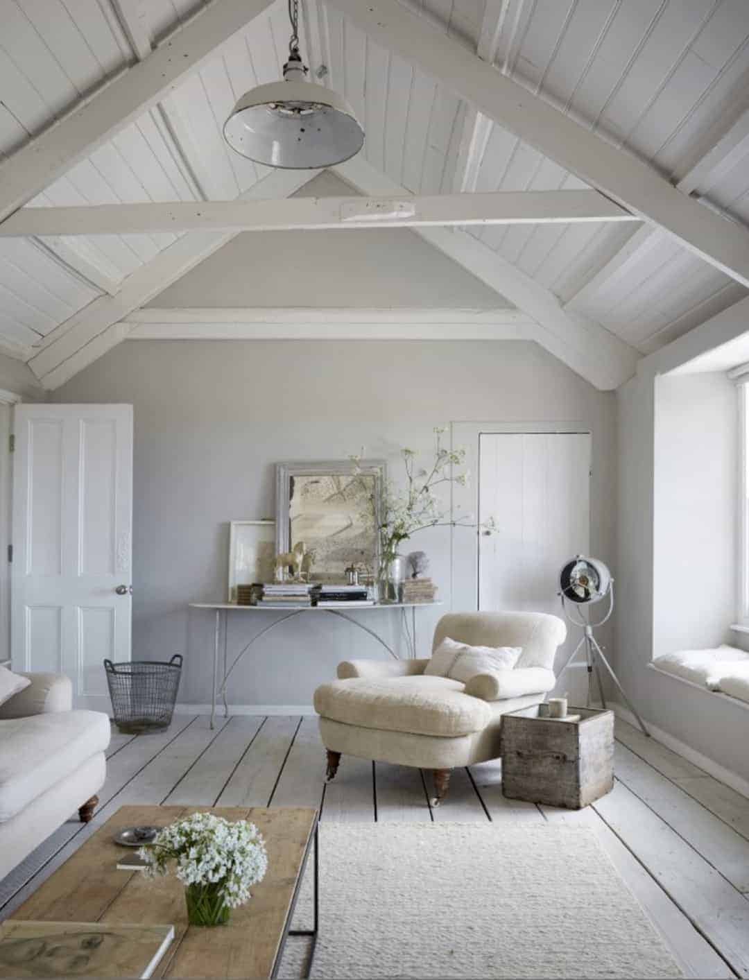 love this seaside coastal vintage loft living room with whitewashed floorbards, vaulted white ceiling and soft grey walls