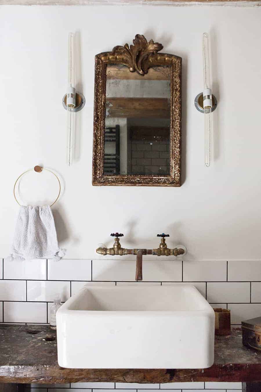 love this modern rustic bathroom by Joraima Tromp of Bricks Studio Amsterdam, with white square sink, old brass taps, vintage gilt mirror and rustic wood top with white metro tiles. Click through for more modern rustic country interiors you'll love