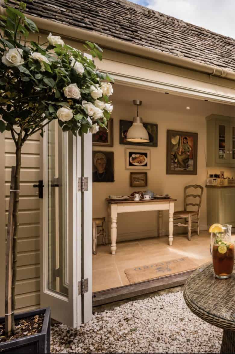love this modern rustic courtyard terrace garden created using simple bifold french doors with stone floor, gravel, original btc lighting and vintage paintings with painted clapboard walls on the exterior it's just one of the beautiful properties available to book through Unique Stays 