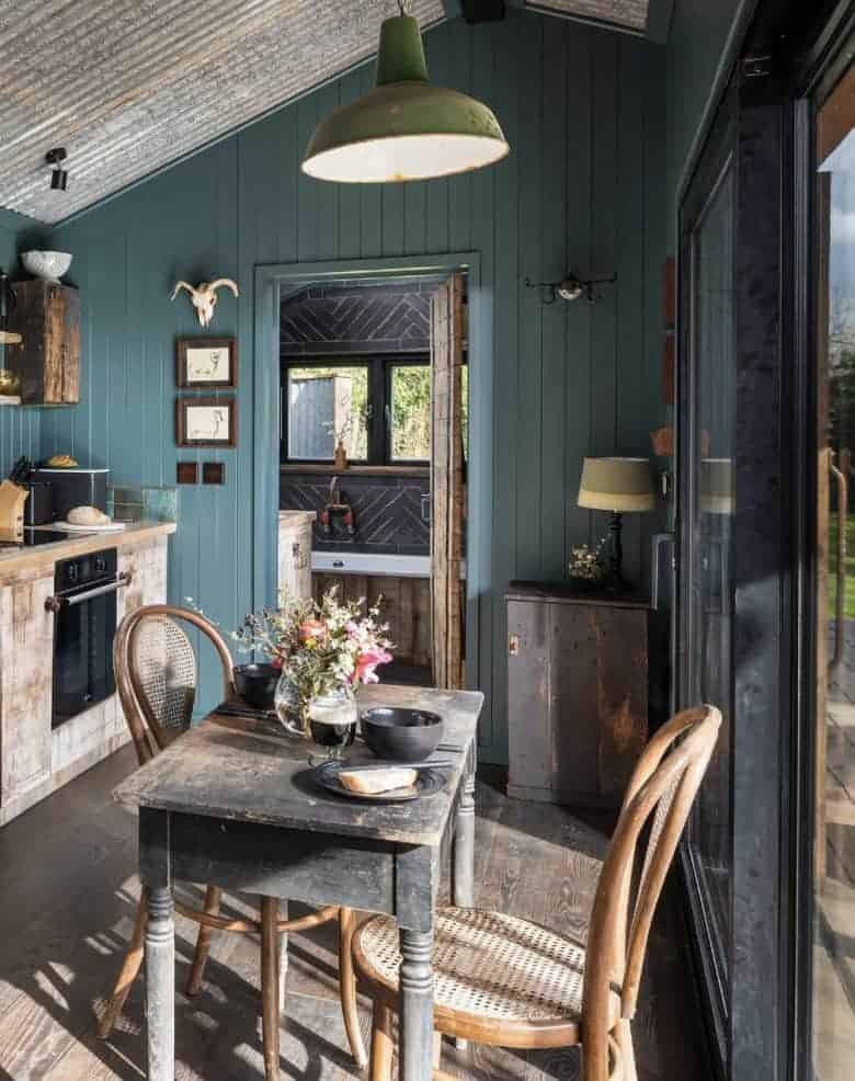 modern rustic kitchen diner decorating idea - dark teal tongue and groove walls with reclaimed wood kitchen units, vintage dining table and industrial lighting from original btc with sliding doors bifold french opening on to dining terrace #modern #rustic #kitchen #diner #reclaimed #teal