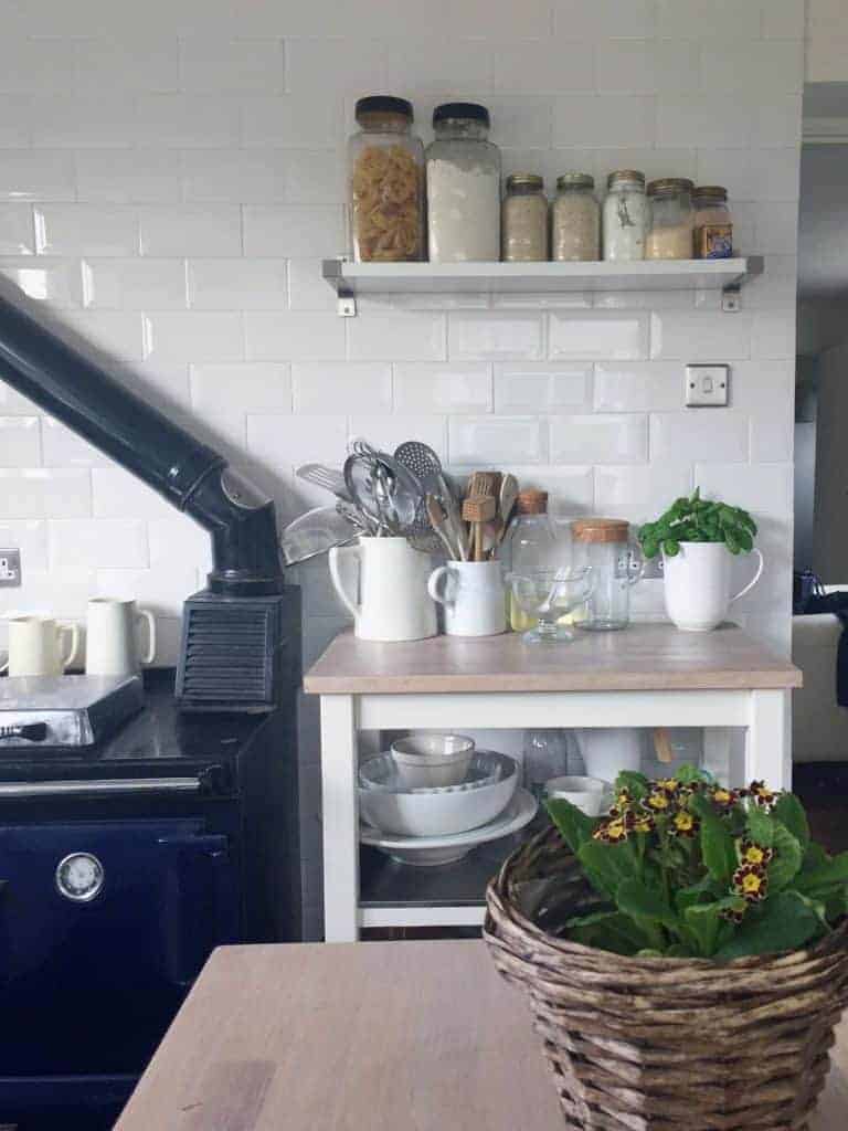 love this contemporary country kitchen look with white metro tiles, blue aga and open shelf with mason storage jars and white ceramaic jugs