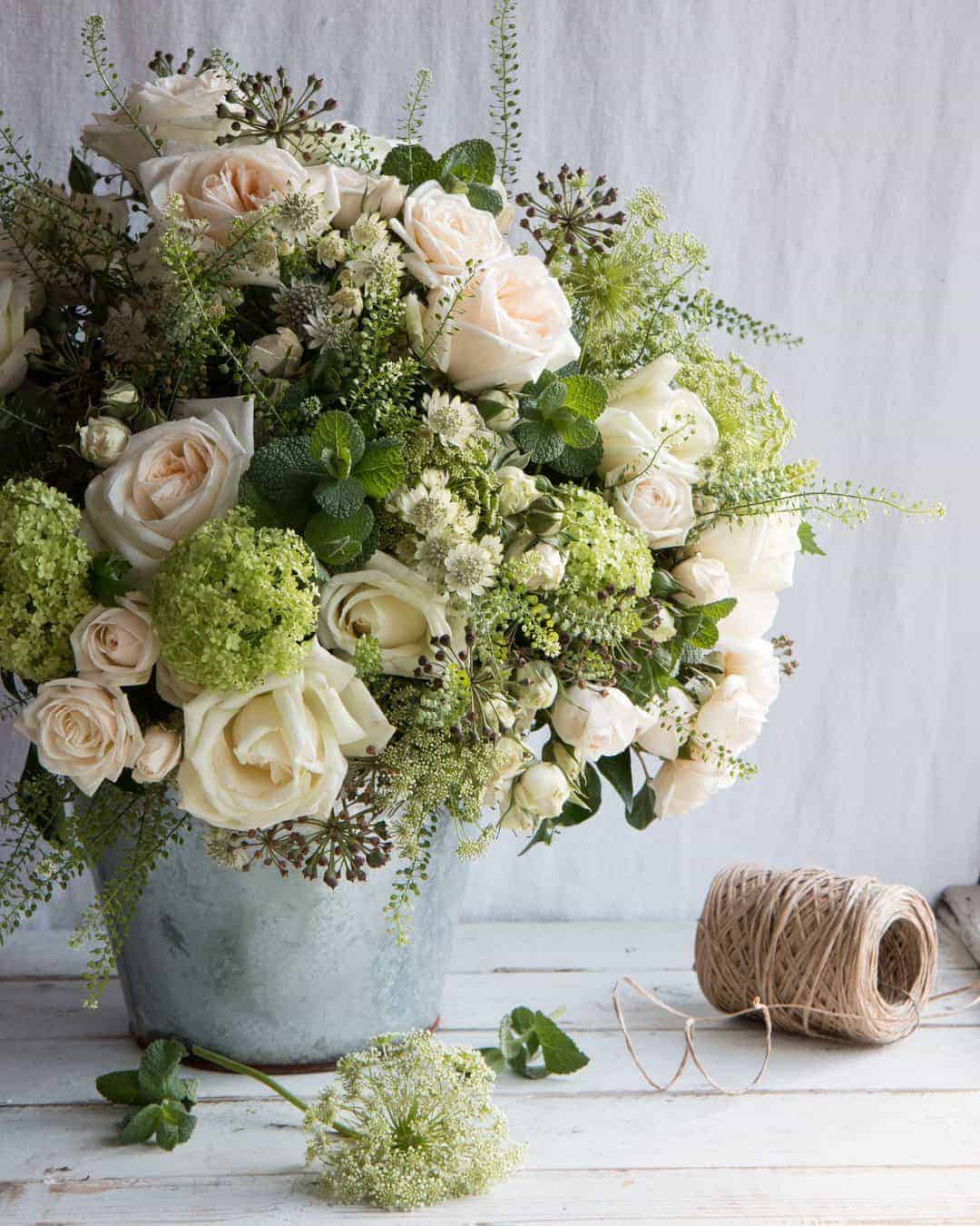 love these pale pink, white and lime green spring flowers by The Real Flower Company - margaret merrill scented roses, fresh mint, seed heads, lime white wild flowers, blossom in a galvanised metal pot. Click through for more beautiful spring flower arrangement ideas you'll love