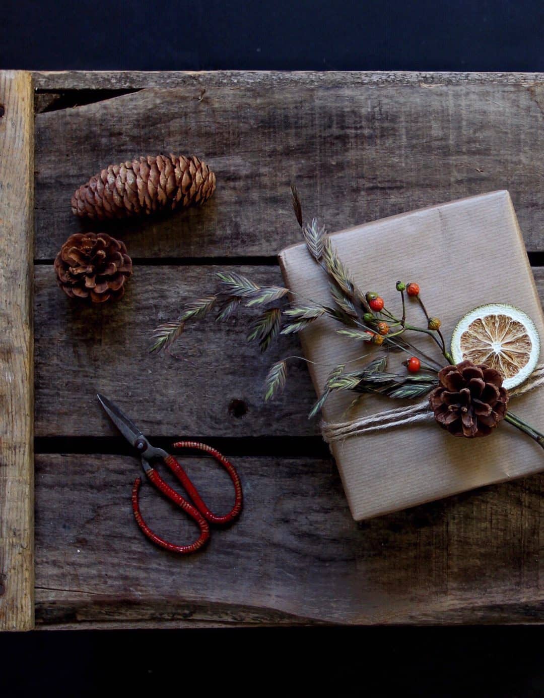 love this kraft paper gift wrap with sting, pine cones, berries and dried lime. Click through for more ethical eco-friendly and plastic free christmas gift wrapping ideas you'll love to try