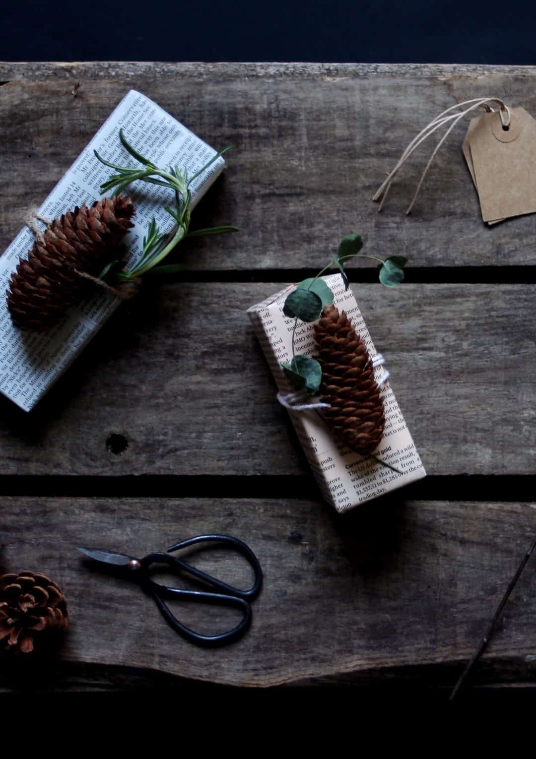 love this idea of using recycled newspaper christmas gift wrap with pine cones and natural string. Click through for more ethical eco-friendly and plastic free christmas gift wrapping ideas you'll love to try