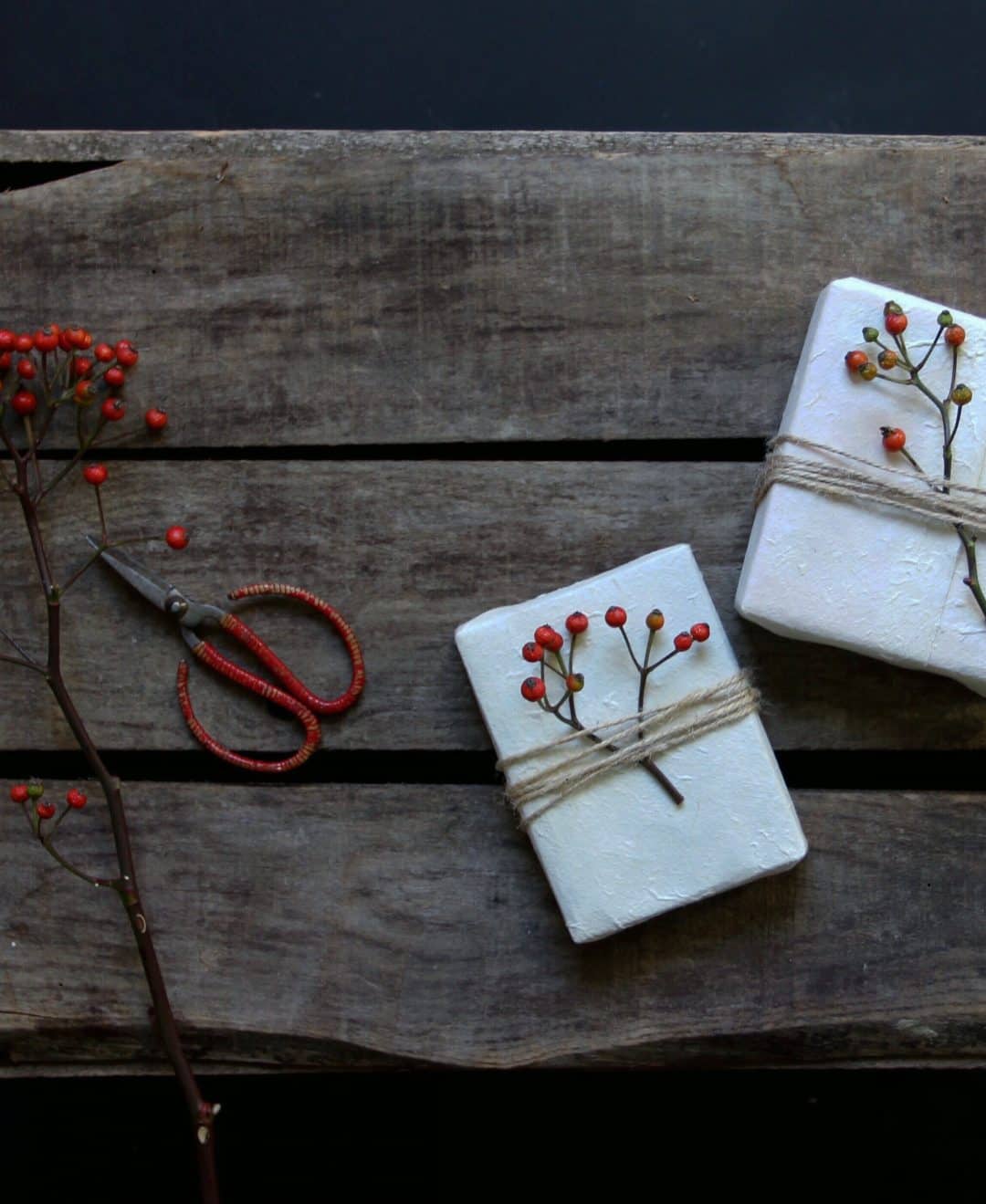 love this idea of using white paper christmas gift wrap with string and red berries. 