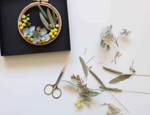 How to make embroidery hoop art with dried flowers. Olga Prinku shares her simple step by step DIY tutorial to create your own mini hoop with hydrangea, eucalyptus, mimosa and spring flowers. Click through for other stunning ideas you'll love to try too #embroideryhoop #embroideryhoopart #driedflowers #frombritainwithlove #olgaprinku #DIY #tutorial #howtomake #embroideryhoopcraft #idaes