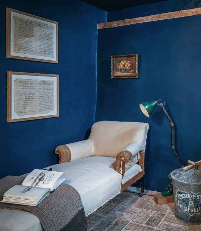 deep blue walls country cottage living room with wooden beams, old brick floor and vintage reupholstered chaise and paintings #blue #cottage #livingroom