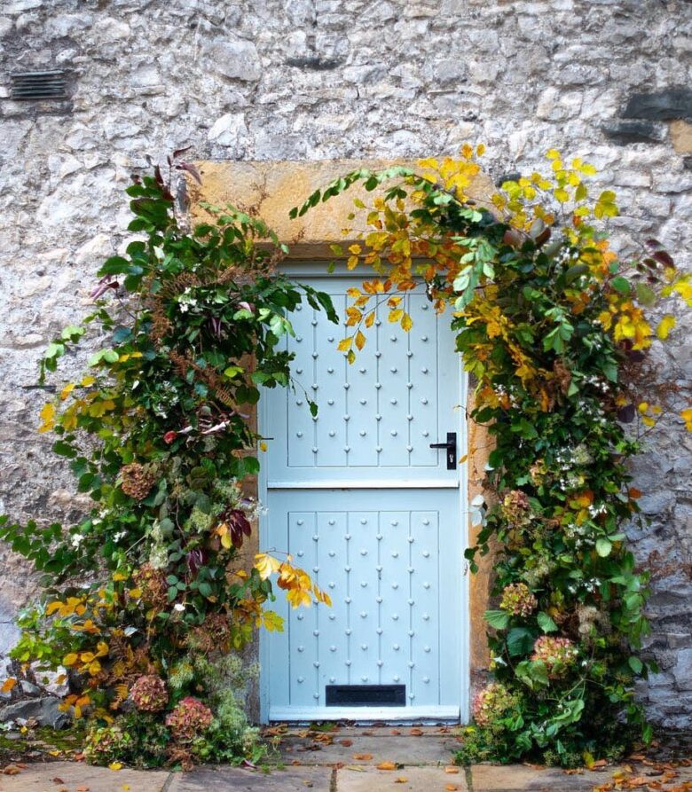 autumn foliage and flowers doorway decoration by sarah diligent of floribunda rose florists at a sustainable floristry workshop with tallulah rose flowers