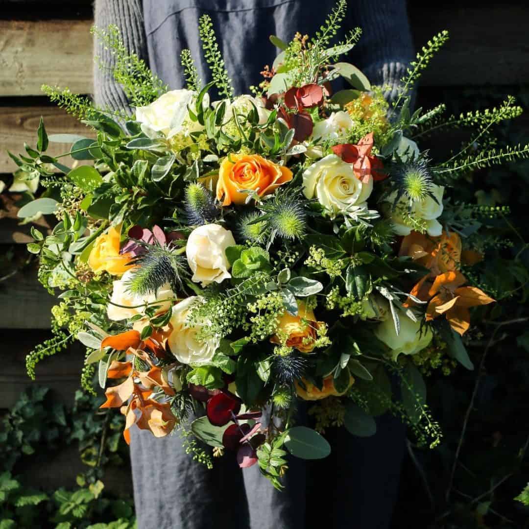 love this autumn flower bouquet by The Real Flower Company including orange roses, autumn leaves, cream roses and herbs