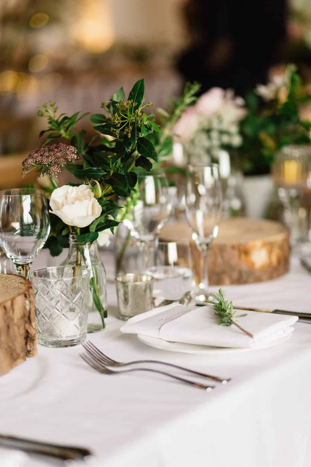 love this simple rustic christmas flowers idea by Sarah Diligent combining simple milk bottles with foraged foliage, single blush roses, herbs and cross section slices of wood to contrast with the classic white linen table cloth. Click through for more DIY christmas flower centrepiece ideas you'll love to try this holiday season