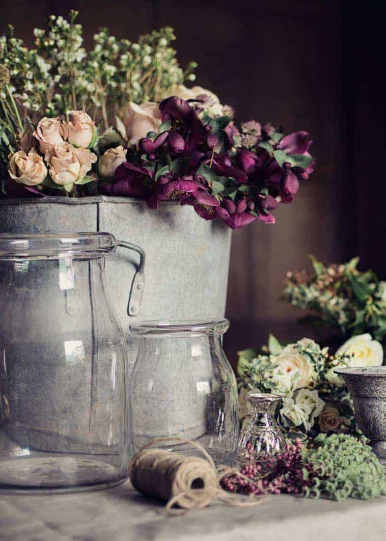 love this combination of purple hellebores, blush roses and lime white wax flowers with vintage galvanised zink and simple glass jars at Pod & Pip christmas flowers workshop. Click through for creative DIY christmas flower arrangement and table centrepiece ideas you'll love to try this holiday season