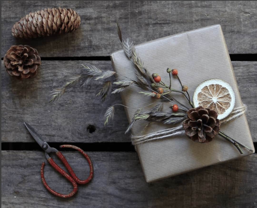 love this kraft paper gift wrap with sting, pine cones, berries and dried lime. Click through for more ethical eco-friendly and plastic free christmas gift wrapping ideas you'll love to try