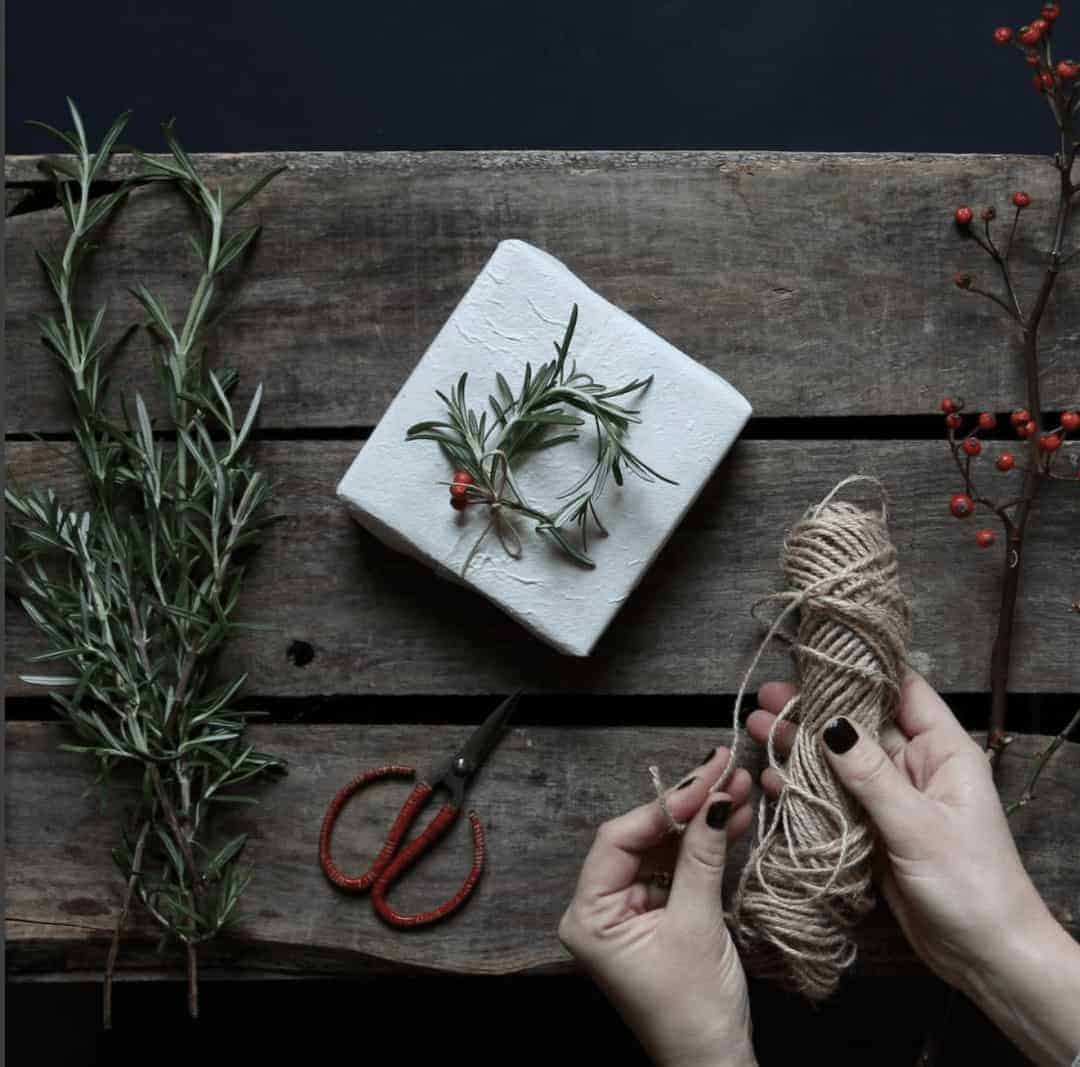 love this idea of making a mini wreath with fresh rosemary to use as gift wrap decoration with simple natural paper and string. Click through for more ethical eco-friendly and plastic free christmas gift wrapping ideas you'll love to try