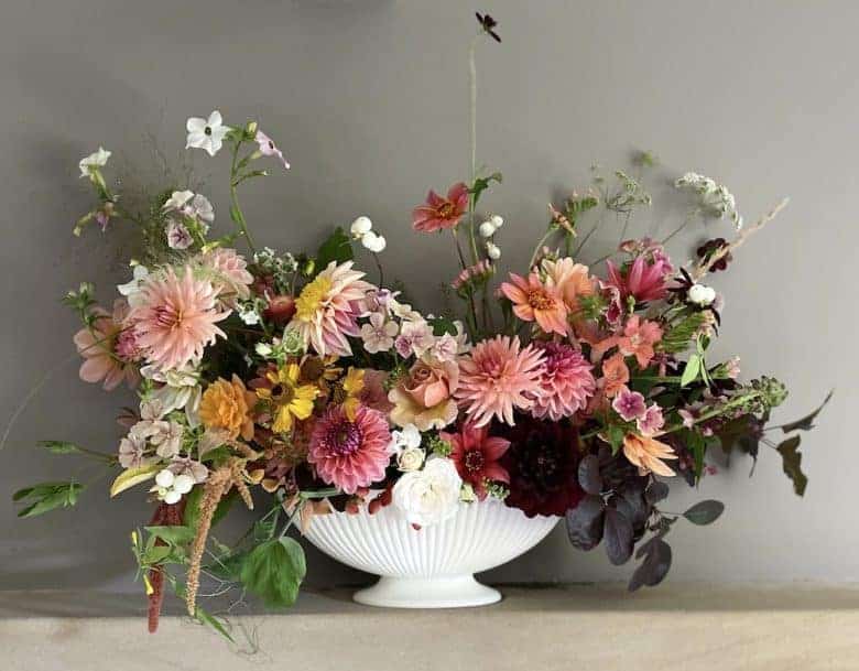 summer flowers white urn arrangement pink and apricot dahlias, snapdragon, amaranthus, snowberries, white wild flowers and seasonal british flowers