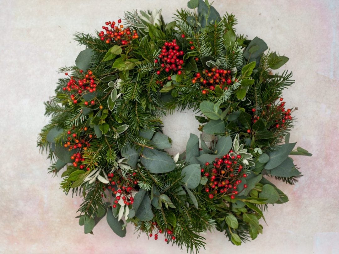how to make a christmas centrepiece with fresh foraged festive greenery, holly, berries and foliage with expert step by steps and tutorial by the real flower company. Add a candle and you're good to go