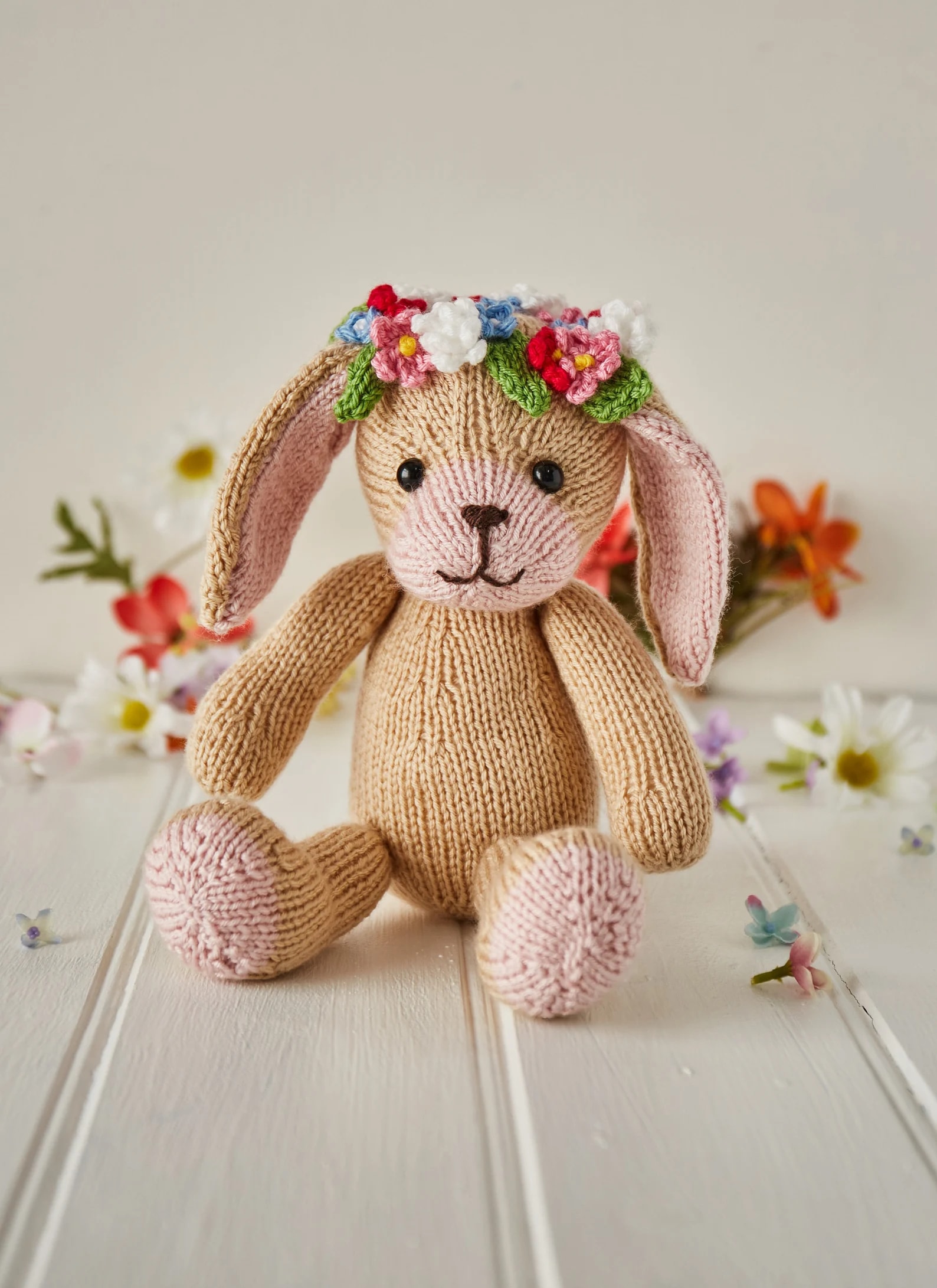 bunny rabbit soft toy knitting pattern with knit crochet flower garland headdress and cuddly, cute face and floppy ears